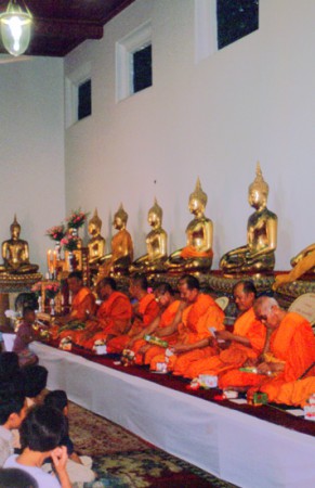 monaci buddhisti ricevono offerte votive 