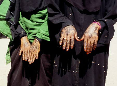 donne mostrano mani decorate con l'hennè